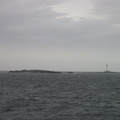 Rock way out at sea with lighthouse attatched