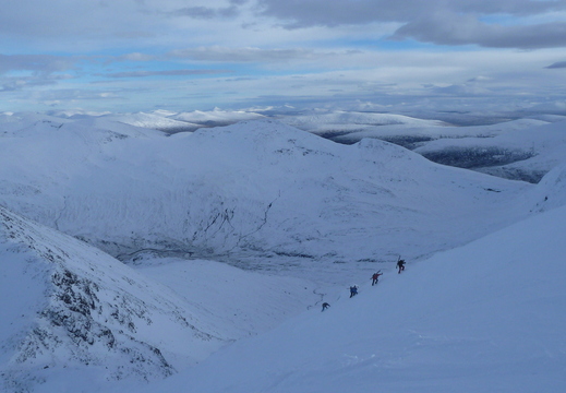 Folks bootpacking back up summit gully