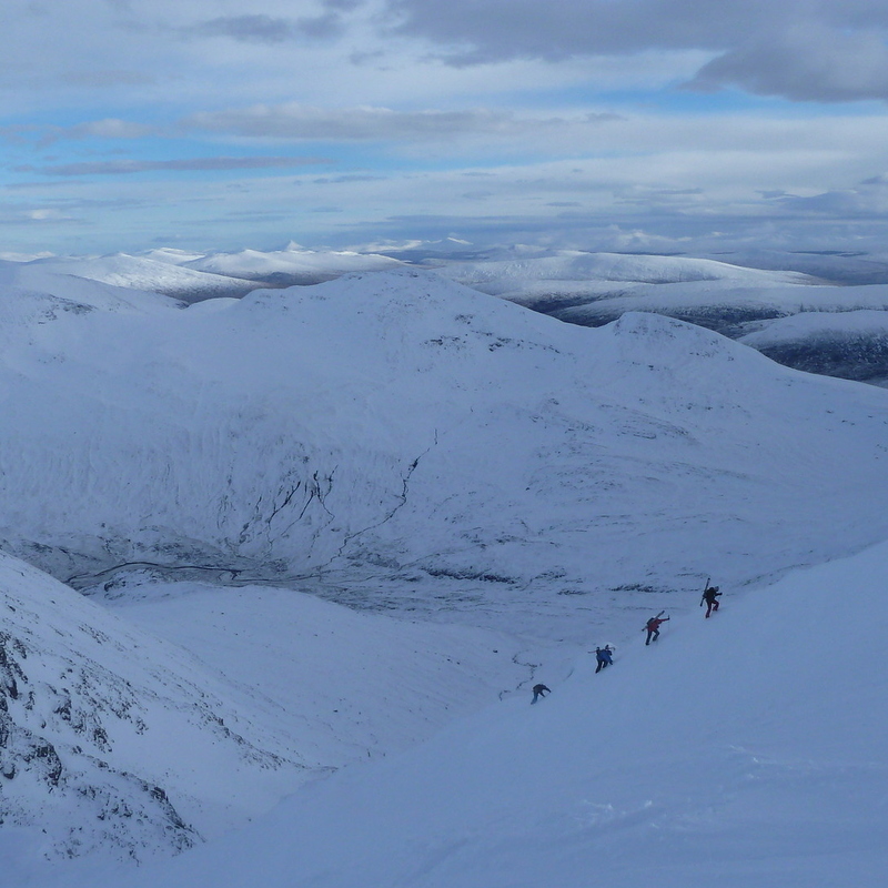 Folks bootpacking back up summit gully